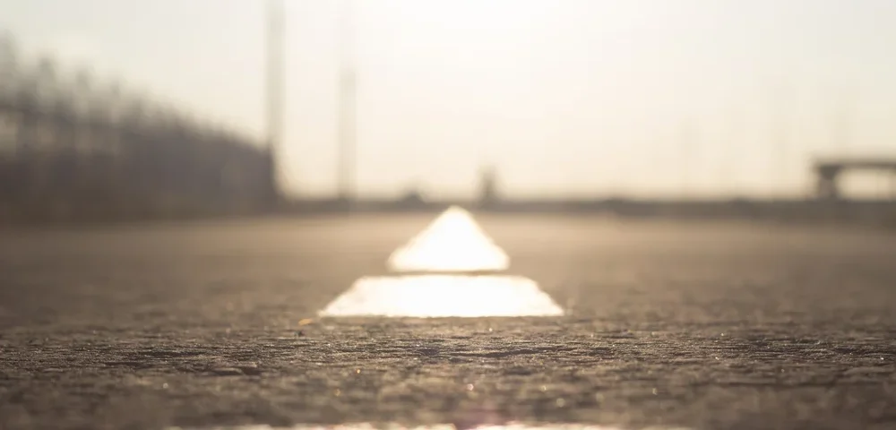 road markings go beyond the horizon. dividing line on the asphalt blurred. lane for cars and cyclists in bright sunlight. road safety idea