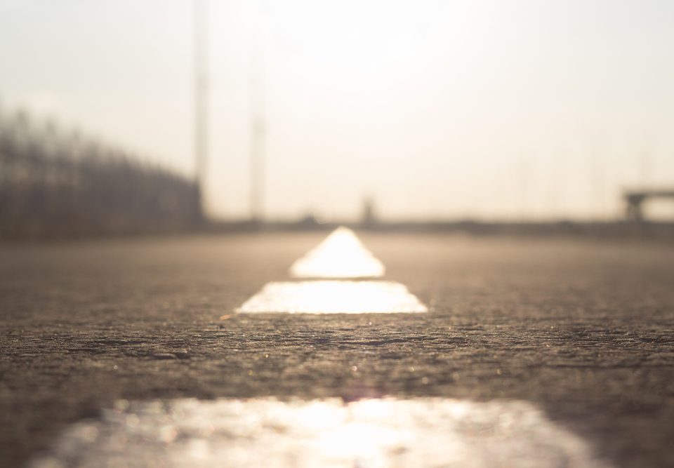 road markings go beyond the horizon. dividing line on the asphalt blurred. lane for cars and cyclists in bright sunlight. road safety idea