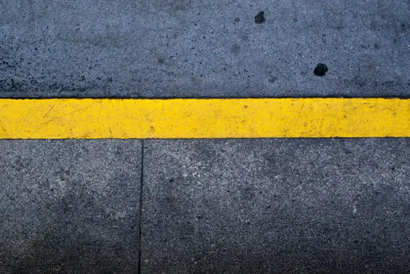 yellow line and strips, caution sign, on asphalt background