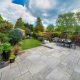 Beautiful summer garden in England, UK with lawn and large, indian sandstone patio.