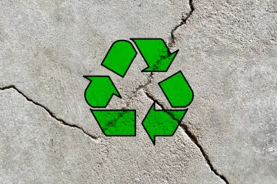 Green recycle arrow icon on a cracked cement wall background, reuse waste construction materials, be environment responsible, sustainable development, creative environment friendly symbol wallpaper