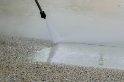 Spray jet cleaning exposed aggregate concrete driveway