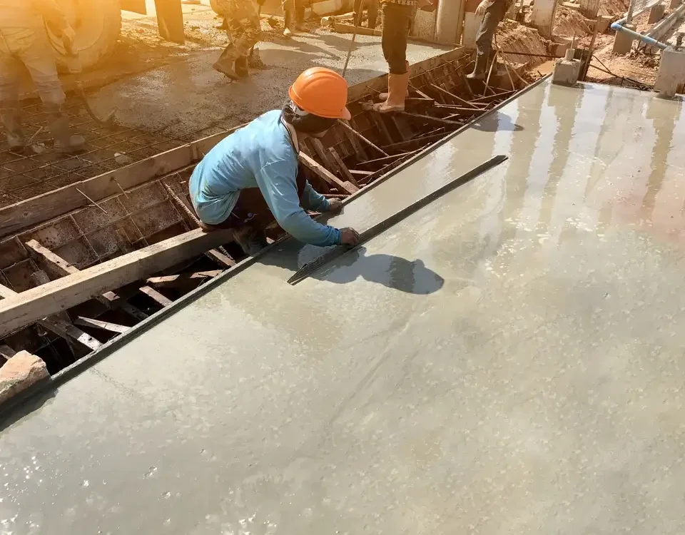 man hand spreading concrete mix with trowel in foundation. A construction worker is pouring cement and concrete,