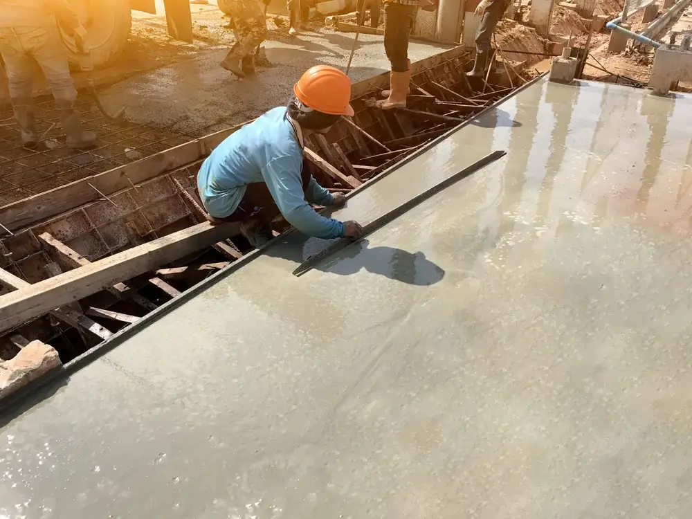 man hand spreading concrete mix with trowel in foundation. A construction worker is pouring cement and concrete,