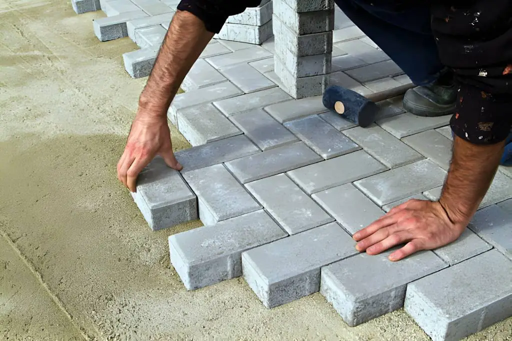 Construction of pavement. Worker puts paving