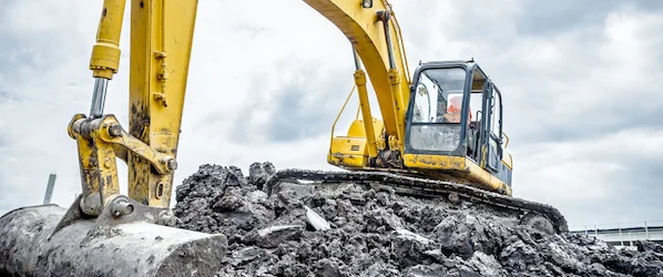 Excavator performing site excavation and earthmoving work on construction site